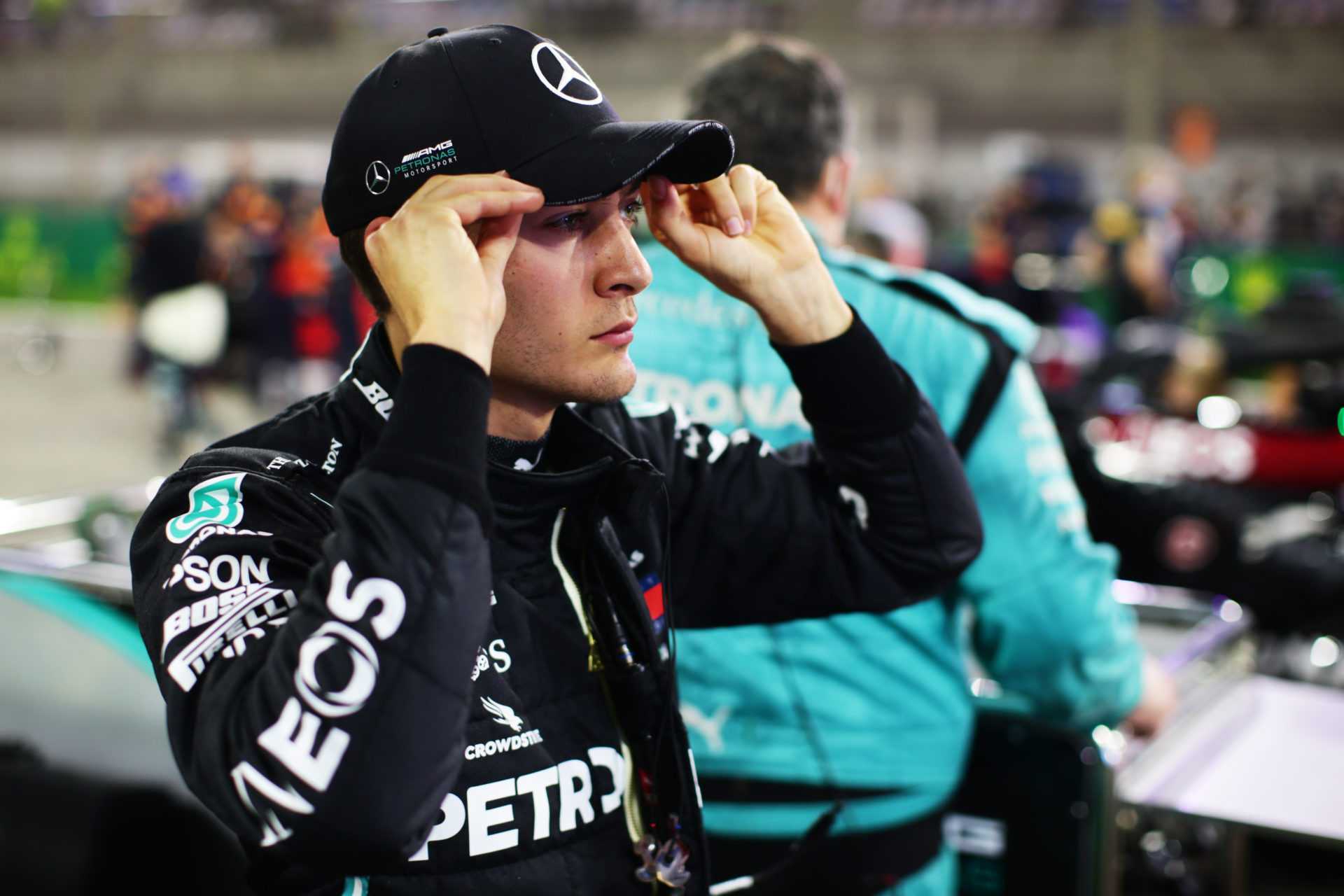 George Russell ajuste sa casquette Mercedes alors qu'il regarde avant le GP de Sakhir