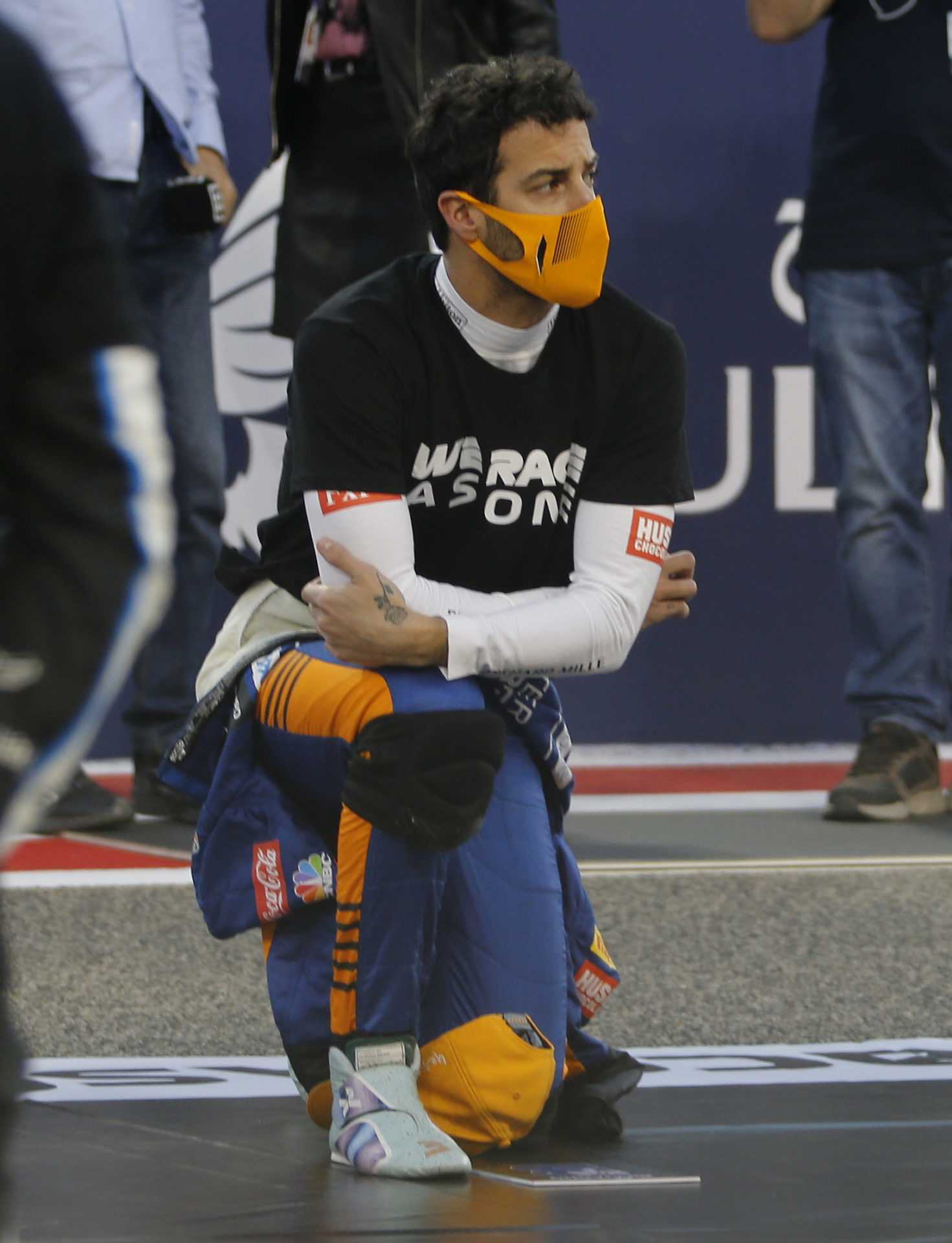Le pilote McLaren Daniel Ricciardo prend le genou devant le GP de Bahreïn